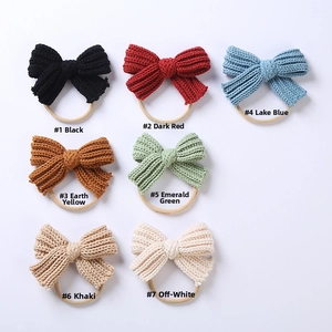Detailed flat lay of seven colorful knit bow headbands with elastic nylon bands for babies
