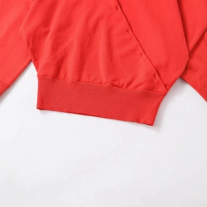 Women's red knit jacket with unique diagonal placket and ribbed hem on white background