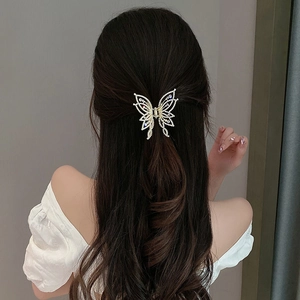 Elegant gold butterfly hair claw clip with white rhinestones and pearls on model