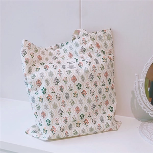 Detail shot of vintage floral cotton tote bag with printed label and sturdy canvas texture