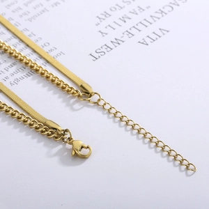 Detailed macro view of gold-plated snake and cable chain layers with lobster clasp