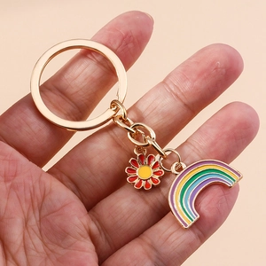Detail of colorful rainbow and daisy flower pendants on a gold enamel keychain