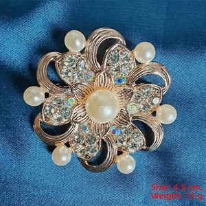 Detail view of 4.5cm gold flower brooch with white pearls and sparkling crystals
