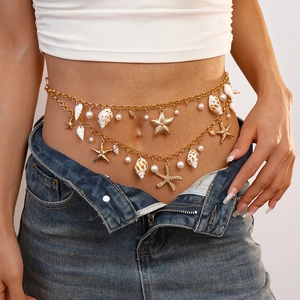 Detail of bohemian gold layered body chain with starfish, shells and faux pearls