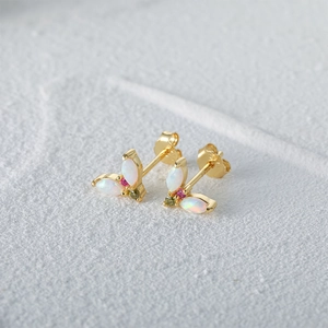 Macro view of V-shaped gold S925 silver stud earrings with opal and colorful gemstones