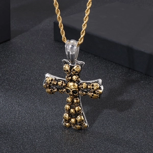 Detail of gothic stainless steel cross pendant featuring 3D golden skulls and rope chain