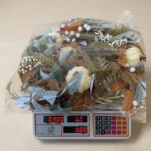 Detail of autumn wreath with white pumpkins and berries in simple packaging weighed on a scale