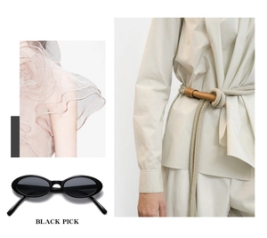 Detail view of oval black sunglasses and beige braided belt set in a stylish layout