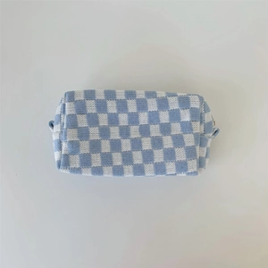 Detailed texture of blue and white checkered knitted cosmetic bag on white background