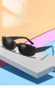 Detail view of children's matte black rectangular sunglasses on geometric background
