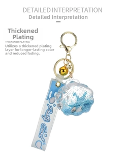Detail of blue acrylic shell keychain with liquid glitter, mini shells and bell