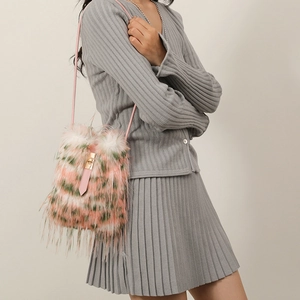 Chic pink and green faux fur shoulder bag with golden lock and slim strap on a model