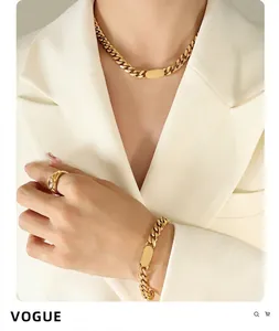 Gros plan détaillé de l'ensemble de bijoux en chaîne dorée, collier, bracelet et bague