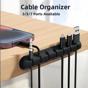 7-slot black silicone desk cable organizer holder with adhesive base on wooden surface