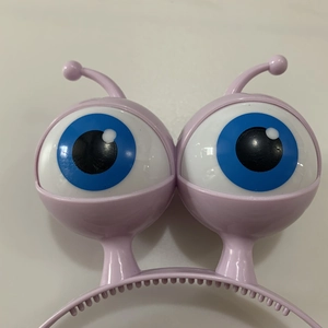 Close-up of glowing purple alien headband with springy eyeballs for Halloween costumes