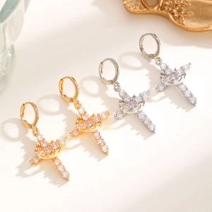 Luxurious gold and silver cross earrings set with sparkling cubic zirconia on white background