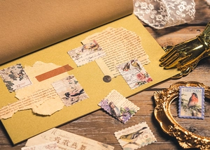 Macro detail of vintage bird and floral postage stickers on aged paper scrapbook