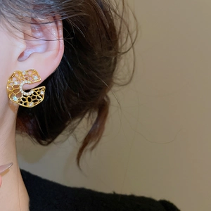 Detailed view of vintage gold hollow C-shaped earrings with zircon crystals on model