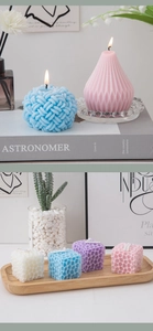 Macro detail of geometric scented candles in blue and pink with a textured wax surface