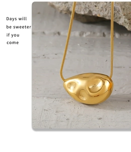 Detailed macro view of 18k gold plated geometric molten pendant on a sleek snake chain