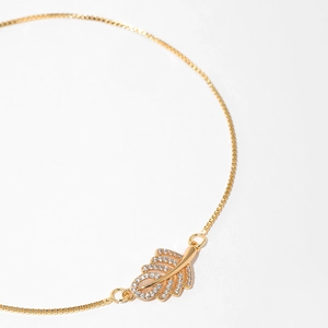 Close-up of gold-plated leaf bracelet with box chain and sparkling zircon pavé