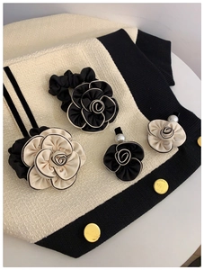 Detailed shot of camellia hair scrunchies and pearl clips on tweed fabric background