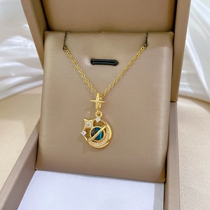 Detail of gold star and moon saturn pendant with blue beads and crystals on silk
