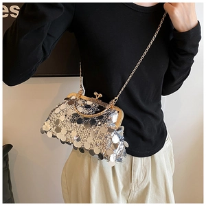Silver sequin crossbody bag with chain strap and vintage clasp closure on a model