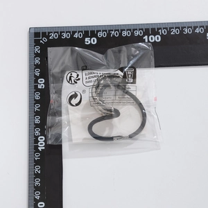 Detailed view of black elastic hair tie with silver metal buckle in protective packaging