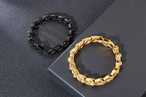 Detail of vintage skull punk bracelets in matte black and gold with relief carvings