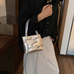 Minimalist silver handbag with decorative bows and metal chain strap for women