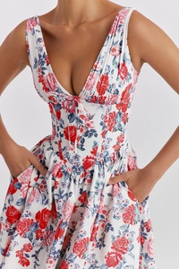 Detail of V-neck floral dress showing corset waist design and red flower print pattern