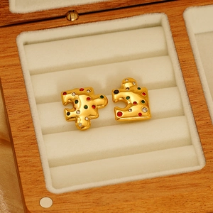 Golden puzzle-shaped titanium steel earrings with colorful crystals in a wooden box