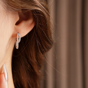 Close-up of minimalist silver double hoop earrings with cubic zirconia on model's ear