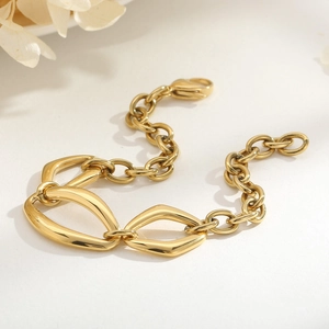Close-up of a gold geometric lobster clasp bracelet with polished link chain details