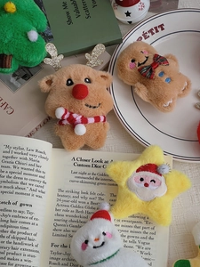 Flat lay of plush Christmas brooches featuring reindeer, gingerbread man, and snowman details