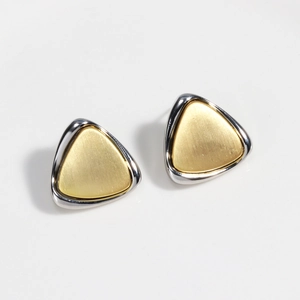 Detail of two-tone triangle stud earrings featuring gold brushed center and silver polished edges