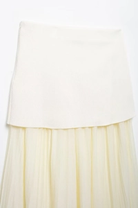 Detail of elegant pleated mesh stitching and cream fabric layers on this long skirt
