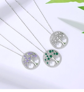Detail of tree of life necklaces with purple, green and white crystal pendants in silver