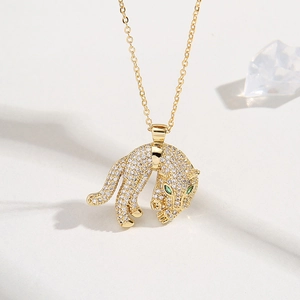 18K gold plated brass necklace with a white zircon paved leopard pendant and green gem eyes
