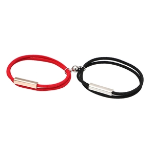 Magnetic couples bracelets with red and black rope, stainless steel charms on white background