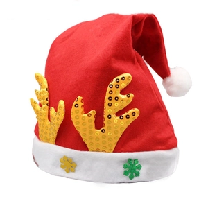Detail of red felt Christmas hat with golden sequin reindeer antlers and snowflake patterns