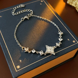 Détail d'un bracelet en argent avec breloque étoile et zircons sur une boîte cadeau