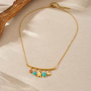 Gold bohemian necklace with starfish shell charms and blue stone on a beach sand background