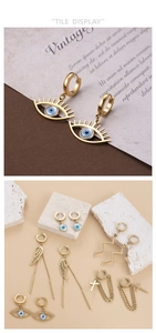 Detail display of gold evil eye earrings and snake pendants on a textured background