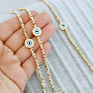 18K gold plated beaded bracelet with blue evil eye charms and spiral texture beads