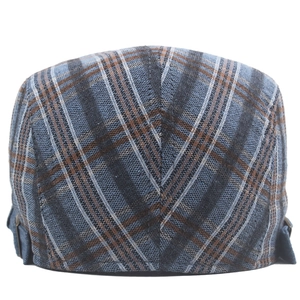 Detail of colorful plaid beret featuring adjustable side straps and woven fabric texture