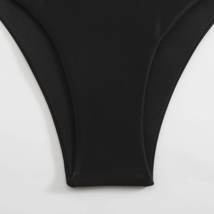 Detailed close-up of seamless stitching and elastic fabric on black high-slit bikini