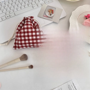 Classic red and black plaid drawstring pouches on a minimalist desk with office accessories