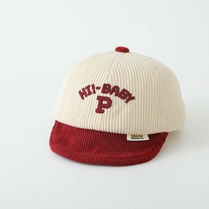 Detail of baby corduroy cap featuring red HI-BABY P embroidery and striped texture